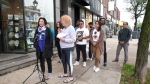 A group of merchants along Queen Mary Street in NDG hold a petition with more than 500 signatures opposed to the city's plans for a reserved bus and taxi lane implemented during peak hours. (Iman Kassam/CTV News)