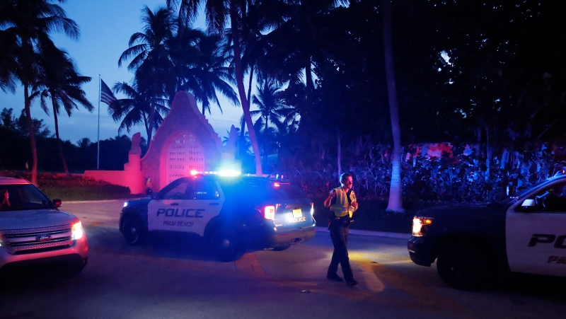 Police direct traffic outside an entrance to former President Donald Trump's Mar-a-Lago estate, Monday, Aug. 8, 2022, in Palm Beach, Fla. Trump said in a lengthy statement that the FBI was conducting a search of his Mar-a-Lago estate and asserted that agents had broken open a safe. (AP Photo/Terry Renna) 
