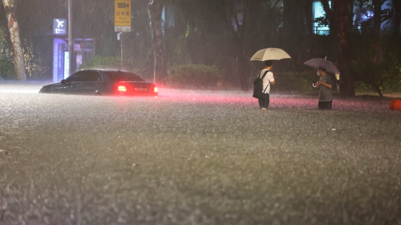 A vehicle is submerged in a flooded road in Seoul, Monday, Aug. 8, 2022. Heavy rains drenched South Korea's capital region, turning the streets of Seoul's affluent Gangnam district into a river, leaving submerged vehicles and overwhelming public transport systems. (Hwang Kwang-mo/Yonhap via AP) 