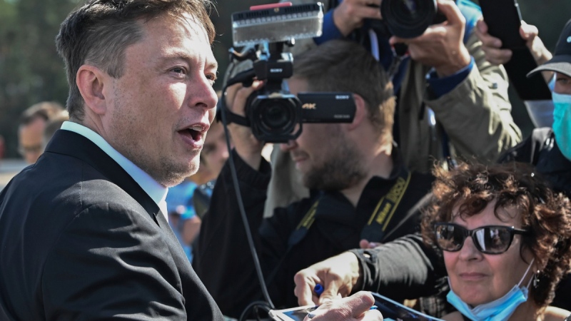 Elon Musk signs autographs at the Tesla Gigafactory construction site in Gruenheide near Berlin, Germany, on Sept. 3, 2020. (Patrick Pleul / dpa via AP) 