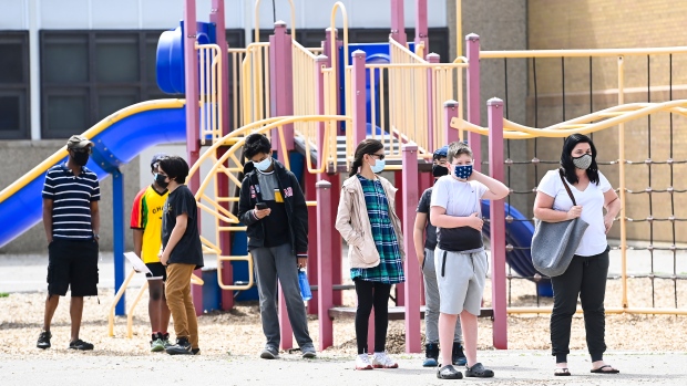 Families and youth aged 12 and older line up for a COVID-19 vaccine at Gordon A Brown Middle School in Toronto Wednesday May 19, 2021. THE CANADIAN PRESS/Nathan Denette
