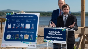 Steven Guilbeault, Federal Minister of Environment and Climate Change, announces the ban of single-use plastics and items at a beach, Monday, June 20, 2022 in Quebec City. Federal Health Minister Jean-Yves Duclos, behind, looks on. THE CANADIAN PRESS/Jacques Boissinot