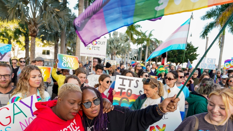 Florida House Representative Michele Rayner, left, hugs her spouse, Bianca Goolsby, during a march at city hall in St. Petersburg, Fla., on Saturday, March 12, 2022, to protest the controversial 'Don't say gay' bill. (Martha Asencio-Rhine/Tampa Bay Times via AP)