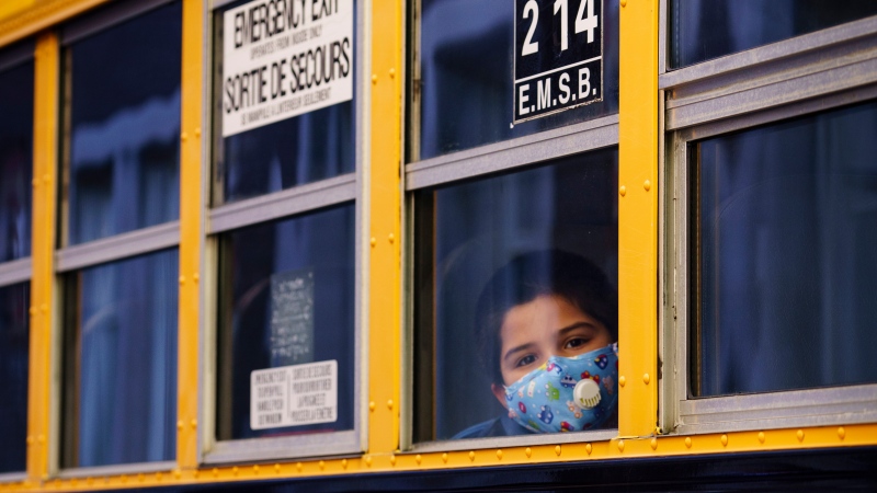 A student looks through the window of a school bus as he arrives at the Bancroft Elementary School in Montreal on August 31, 2020. -- FILE PHOTO (THE CANADIAN PRESS/Paul Chiasson)
