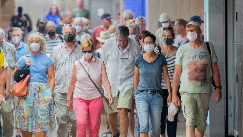 People wear face masks as they walk through a subway station in Montreal, Sunday, July 17, 2022 (THE CANADIAN PRESS/Graham Hughes)