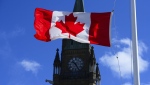 A Canadian flag is pictured with the Peace Tower on Parliament Hill in Ottawa, April 12, 2021. THE CANADIAN PRESS/Sean Kilpatrick