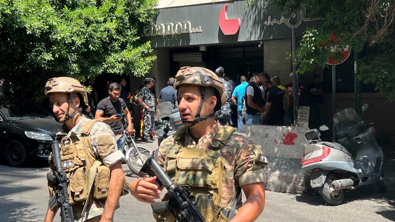 Lebanese security forces secure the area outside a bank in Beirut,, Lebanon, Thursday, Aug. 11, 2022. (AP Photo/Hussein Malla)