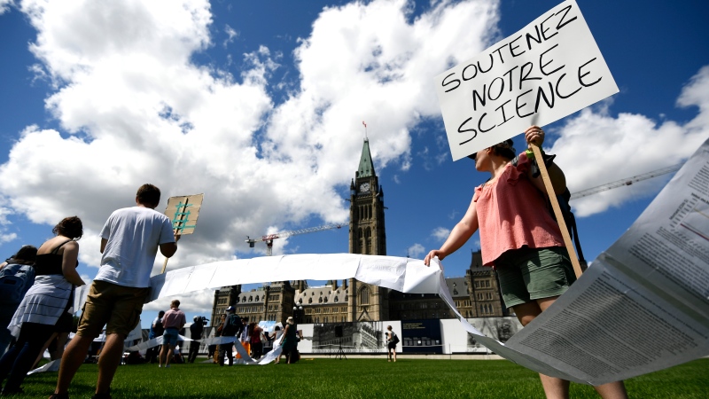Scientists and researchers hold a petition with over 7,100 signatures calling on the federal government to increase funding for graduate and post-doctoral scholars, during the “Support Our Science” rally on Parliament Hill in Ottawa, on Thursday, Aug. 11, 2022. THE CANADIAN PRESS/Justin Tang 