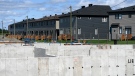 FILE - Foundations for homes under construction are seen in front of completed homes in a new subdivision in the Ottawa suburb of Kanata, on Friday, July 30, 2021. THE CANADIAN PRESS/Justin Tang