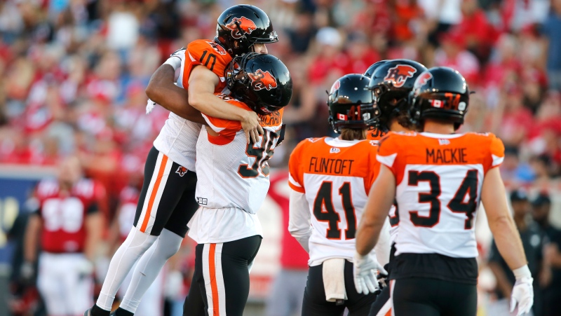 BC Lions kicker Sean Whyte, left, celebrates his winning field goal with defensive end Obum Gwacham (98) near game end CFL football action against the Calgary Stampeders in Calgary, Saturday Aug. 13, 2022 (The Canadian Press/Larry MacDougal).