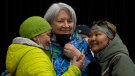 A woman glances up at Governor General Mary Simon after taking a photo together following a community gathering on May 10, 2022 in Kangiqsualujjuaq, Que. (THE CANADIAN PRESS/Adrian Wyld)