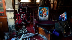 Burned furniture, including wooden tables and chairs, and a religious images are seen at the site of a fire inside the Abu Sefein Coptic church that killed at least 40 people and injured some 14 others, in the densely populated neighbourhood of Imbaba, Cairo in Egypt on Aug. 14, 2022. The church said the fire broke out while a service was underway. (AP Photo/Tarek Wajeh)