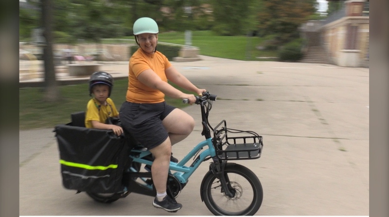 Yolanda Hedberg and her son, seven-year-old Tobias, take a ride on the family cargo bike at Ivey park in London, Ont. on August 14, 2022. (Bryan Bicknell/CTV News London)
