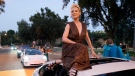 Actress Anne Heche poses atop a car as she arrives at the Drive-In to Erase MS gala, Sept. 4, 2020, in Pasadena, Calif. (AP Photo/Chris Pizzello)