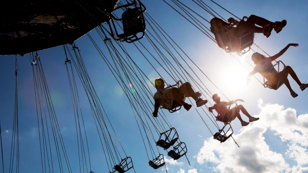 Children spread their hands in the air as they fly in the sky on a giant swing set at the Canadian National Exhibition in Toronto. THE CANADIAN PRESS/Michelle Siu