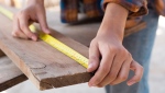 A person seen measuring wood in this file image. (Photo by Los Muertos Crew via Pexels)