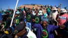Mine workers sing as they wait for the start of commemoration ceremonies near Marikana in Rustenburg, South Africa, Tuesday, Aug. 16, 2022. (AP Photo/Themba Hadebe)