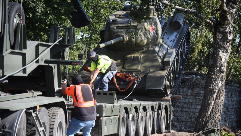 Workers remove a Soviet T-34 tank installed as a monument in Narva, Estonia, Tuesday, Aug. 16, 2022. (AP Photo/Sergei Stepanov)
