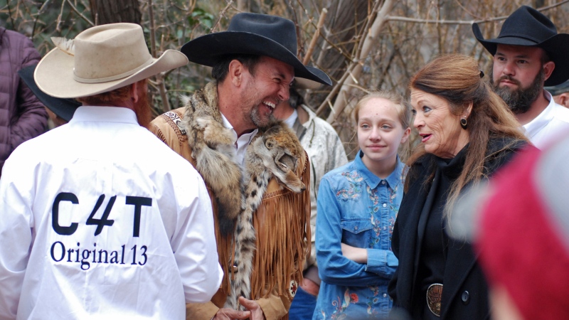 In this March 12, 2019, file photo, Cowboys for Trump leader Couy Griffin, center, talks with Republican New Mexico state Rep. Candy Ezzell of Roswell, N.M., at a protest against gun control and pro-abortion rights legislation outside the New Mexico State Capitol, in Santa Fe, N.M. (AP Photo/Morgan Lee, File)