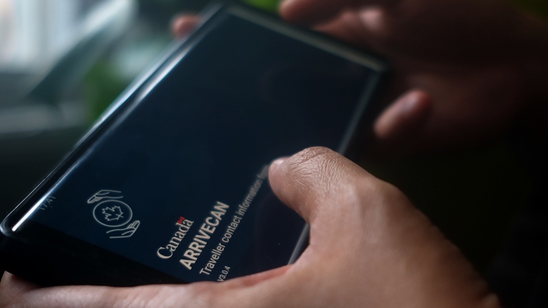 A person holds a smartphone set to the opening screen of the ArriveCan app in a photo illustration made in Toronto, Wednesday, June 29, 2022. THE CANADIAN PRESS/Giordano Ciampini