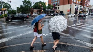 People holding umbrellas on Sunday, July 24, 2022 THE CANADIAN PRESS/Spencer Colby