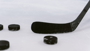 A hockey stuck and pucks. (Pexels)