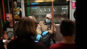 FILE - In this Sept. 12, 2021, an elderly man wearing a face mask and gloves to protect against the coronavirus rides a subway car in Moscow, Russia. (AP Photo/Alexander Zemlianichenko, File)