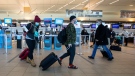 Travelers carry luggage to their flights at the Edmonton International Airport in Edmonton Alta, on Thursday December 2, 2021. THE CANADIAN PRESS/Jason Franson