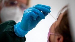 A health care worker administers a COVID-19 test on a child. (Christophe Gateau/picture alliance/Getty Images via CNN)