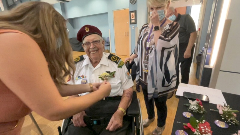 Joe Quinn receives a flower as part of a celebration for residents at Perley Health long-term care home turning at least 100-years-old this year. (Dave Charbonneau/CTV News Ottawa)