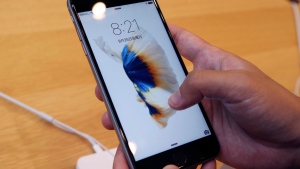 In this Friday, Sept. 25, 2015, file photo, a customer tries a new iPhone 6S on display at an Apple store in Tokyo. (AP Photo/Koji Sasahara, File)