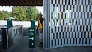 A Greater Vancouver Zoo staff member opens a locked gate in preparation for a news conference about a wolf that died and another that remains missing after a fence was cut at the facility and the animals escaped, in Langley, B.C., on Thursday, August 18, 2022. THE CANADIAN PRESS/Darryl Dyck