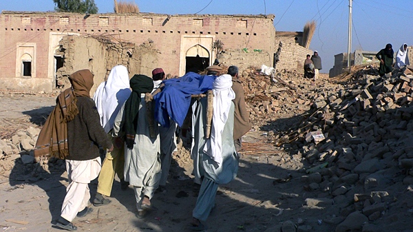 Local residents carry a body through the rubble of houses damaged in Friday's suicide car bombing in Shah Hasan Khel village near Lakki Marwat, Pakistan, Saturday, Jan. 2, 2010 (AP / Naveed Sultan)