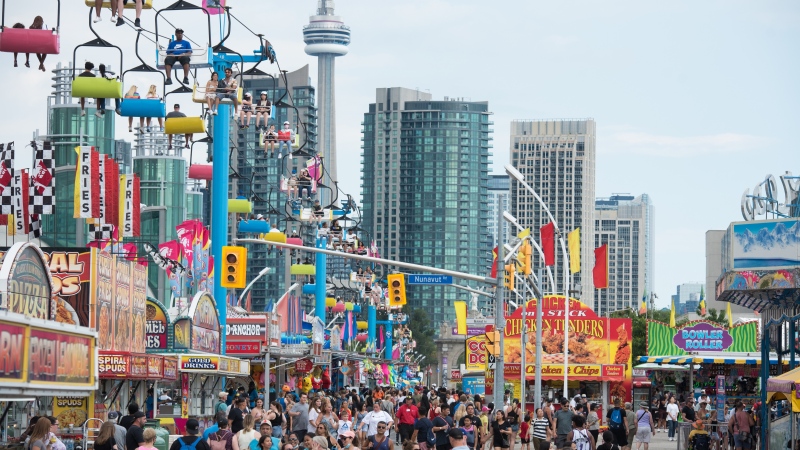 Crowds make their way through the midway during opening day of the Canadian National Exhibition in Toronto on Friday, August 19, 2022. THE CANADIAN PRESS/Tijana Martin