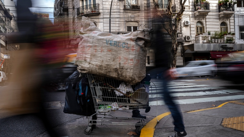 A worker who recycles cardboard to make a living pushes his cart on a cold morning in Buenos Aires, Argentina, Friday, July 8, 2022. Four of every 10 Argentines are poor and inflation has reached more than 60% in the past 12 months. (AP Photo/Rodrigo Abd)