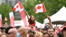 A child waves the Maple Leaf flag during Canada Day celebrations at LeBreton Flats in Ottawa, on July 1, 2022. (Justin Tang / THE CANADIAN PRESS)