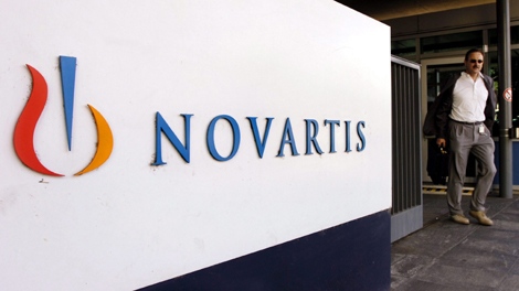 In this Aug. 12, 2005 file photo, a man passes the Logo of Swiss pharmaceutical company Novartis at the company's headquarters in Basel, Switzerland. (AP Photo/Keystone, Steffen Schmidt, file)