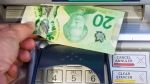 Money is removed from a bank machine Monday May 30, 2016 (The Canadian Press/Ryan Remiorz).