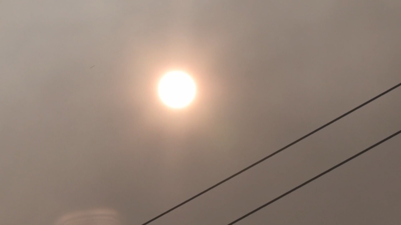 The sun shines through smoke from a fire at a wood recycling facility in South Vancouver on Saturday, Aug. 10, 2022. (CTV)