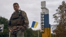 A Ukrainian soldier stands near the sign reading "Kupiansk" in the recently retaken Kupiansk in the Kharkiv region, Ukraine, Wednesday, Sept. 14, 2022. Ukrainian troops piled pressure on retreating Russian forces pressing deeper into occupied territory and sending more Kremlin troops fleeing ahead of the counteroffensive that has inflicted a stunning blow on Moscow's military prestige. (AP Photo/Kostiantyn Liberov) 