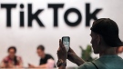 A visitor takes a photo at the TikTok exhibition stand at the Gamescom computer gaming fair in Cologne, Germany, Aug. 25, 2022. THE CANADIAN PRESS/AP, Martin Meissner