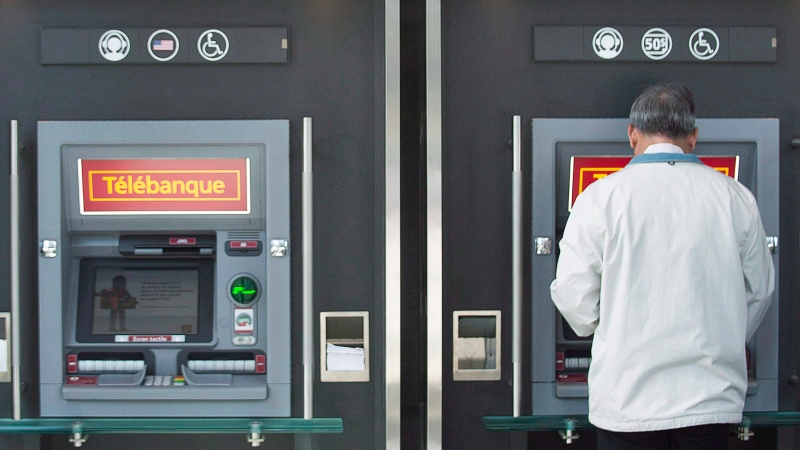 A man uses an ATM in Montreal, on April 24, 2014. THE CANADIAN PRESS/Graham Hughes