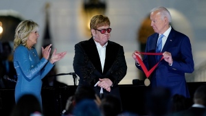 U.S. President Joe Biden presents Elton John with the National Humanities Medal after a concert on the South Lawn of the White House in Washington, Sept. 23, 2022, as first lady Jill Biden watches. (AP Photo/Susan Walsh)