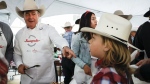 FILE - Alberta Premier Jason Kenney, left, dishes out pancakes at his last Premier's annual Stampede breakfast as premier in Calgary, Alta., Monday, July 11, 2022.THE CANADIAN PRESS/Jeff McIntosh