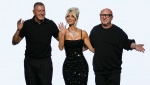 Kim Kardashian, center, is flanked by Domenico Dolce, right, and Stefano Gabbana at the end of the Dolce & Gabbana women's Spring Summer 2023 fashion show presented in Milan, Italy, Saturday, Sept. 24, 2022. (AP Photo/Antonio Calanni)