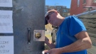 One of the owners of St. Brigid's church changes the locks on the doors of the St. Patrick Street property on Saturday, one day at The United People of Canada were ordered out. (Jackie Perez/CTV News Ottawa)
