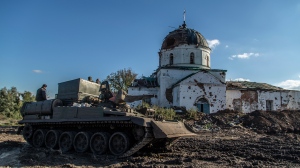 Ukrainian soldiers inspect an abandoned Russian tank in the recently retaken area close to Izium, Ukraine on Sept. 21, 2022. (AP Photo/Oleksandr Ratushniak)