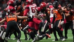Calgary Stampeders' Ka'Deem Carey, centre, runs past B.C. Lions' David Menard (56) and Ben Hladik (46) to score a touchdown during the first half of CFL football game in Vancouver, on Saturday, Sept. 24, 2022. THE CANADIAN PRESS/Darryl Dyck