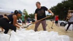 Friends Felicia Livengood, 29, and Victoria Colson, 31, fill sandbags along with hundreds of other residents, Sept. 25, 2022, in Tampa, Fla. (Luis Santana/Tampa Bay Times via AP)