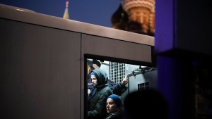 Detained demonstrators inside a police bus during a protest against a partial mobilization near Red Square with the St. Basil's Cathedral in the background in Moscow, Russia, Saturday, Sept. 24, 2022. (AP Photo) 